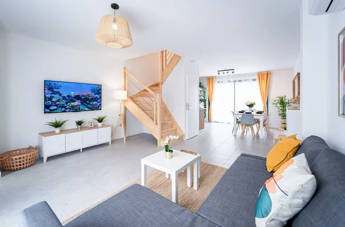 Séjour de logement neuf : peinture, carrelage au sol et escalier livrés